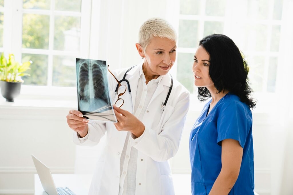 Doctor showing x-ray image of lungs to medical student intern nurse, explaining illness diagnosis